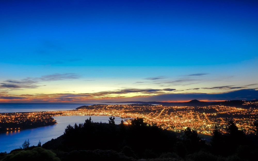 Hill top view of Dunedin City. From the top, one can enjoy beautiful city lights, sunset and colorful sky. Dunedin is a popular tourist destination in South Island of New Zealand.